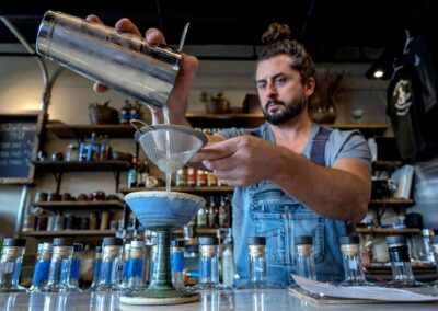 Aio, a bar tender at the Pottery Pub in Santa Fe, makes a Bee's Knees in one of thier ceramic martini glasses, Monday, February 6, 2023. The drink contains high desert gin, rosemary honey syrup, and lemon juice. (Eddie Moore/Albuquerque Journal)